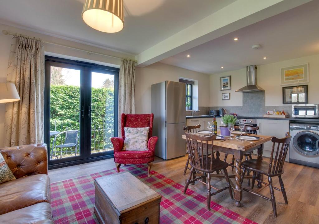 a kitchen and living room with a table and chairs at 3 Hilltop Cottages in Stansted