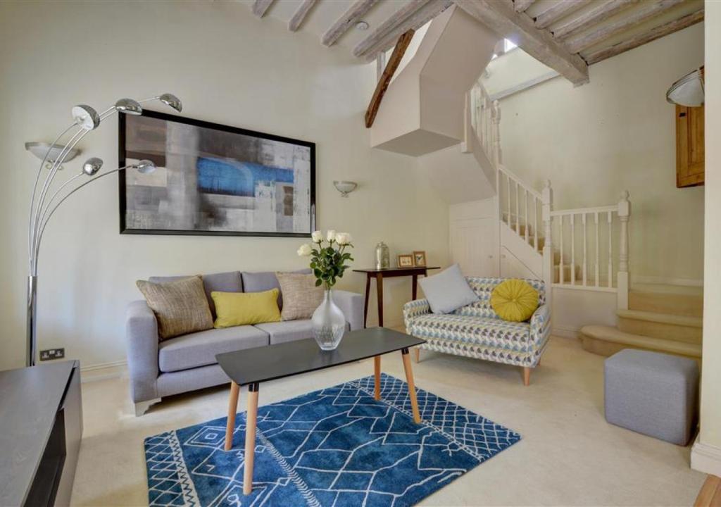 uma sala de estar com um sofá e uma mesa em 3 Stable Mews em Royal Tunbridge Wells