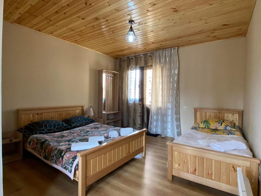 1 dormitorio con 2 camas y techo de madera en Guesthouse Venera, en Mestia