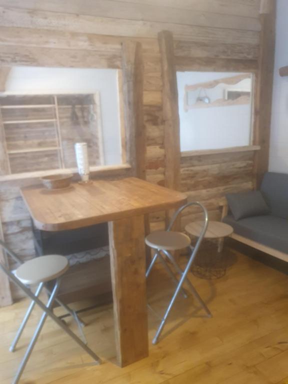 een tiny house met een houten tafel en stoelen bij bienvenue chez les choup;s le p;tit laponie in La Bourboule