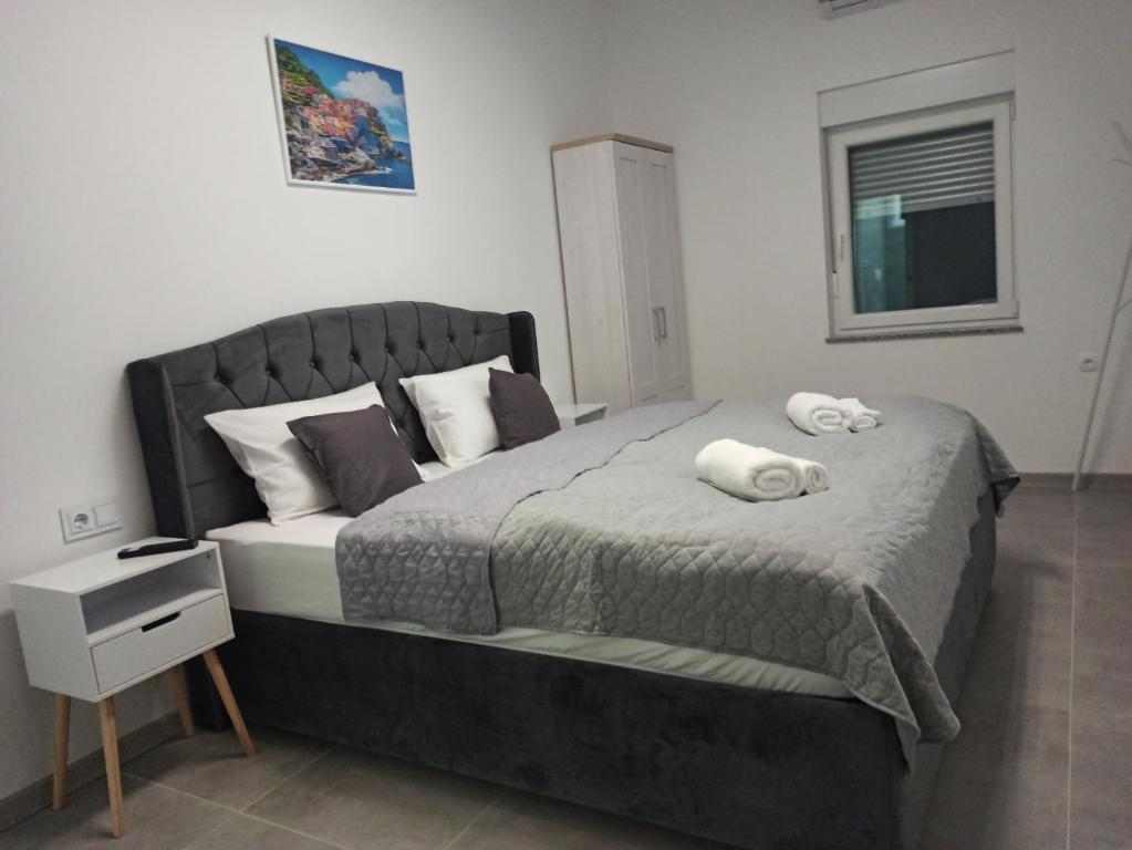 a bedroom with a large bed with two towels on it at Venite Rooms in Velika