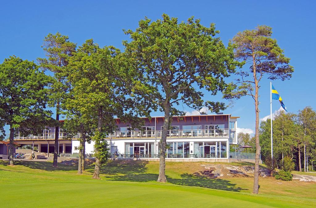 uma grande casa branca com árvores em frente em Sotenäs Golfhotell em Hunnebostrand