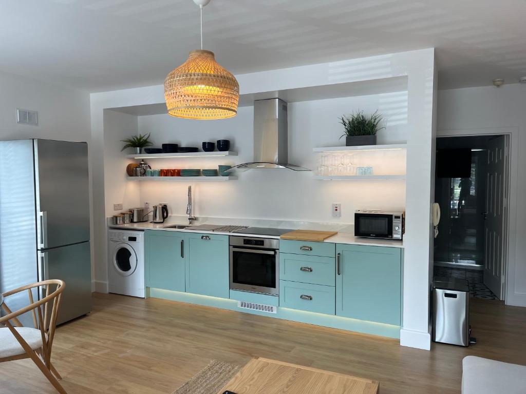een keuken met blauwe kasten en een koelkast bij 2 Bedroom Apartment Central Town Location in Enniscorthy
