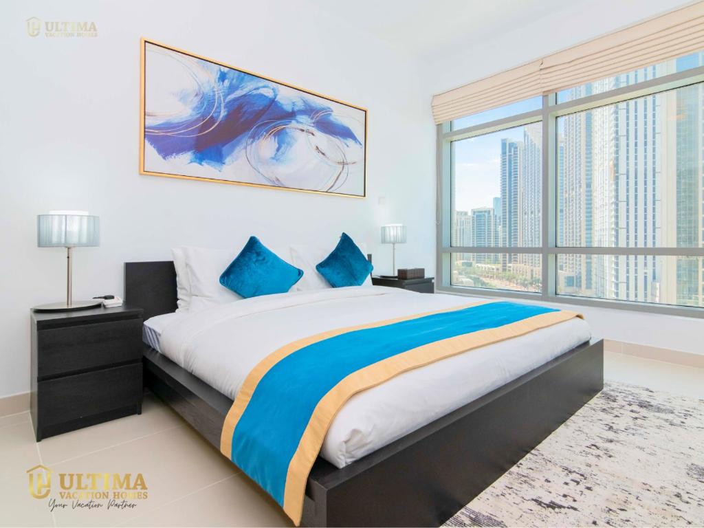 Ultima Vacation Homes loft 1 BR Apartment في دبي: غرفة نوم بسرير كبير ونافذة كبيرة
