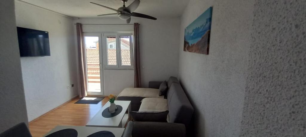 een woonkamer met een bank en een plafondventilator bij Apartment Bougainvillea in Trogir