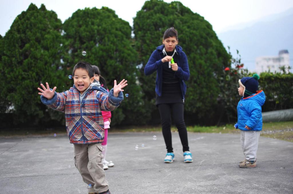 a group of children playing with bubbles in a park at Yunju House in Jiaoxi