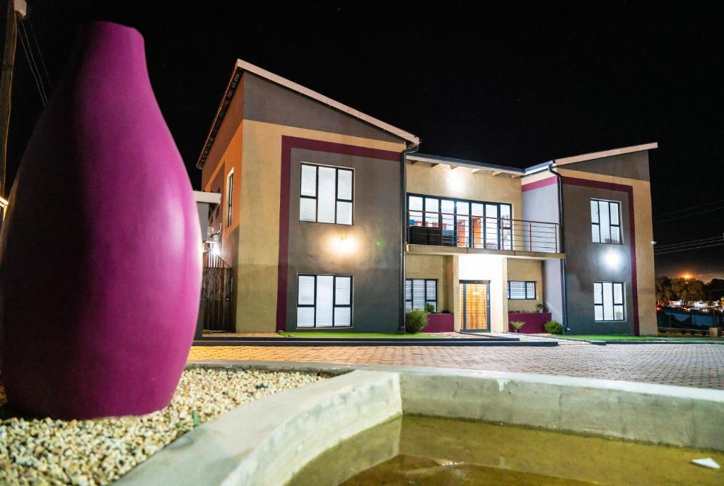 una casa con un jarrón rosa delante de ella en Greenlake Guesthouse en Maseru