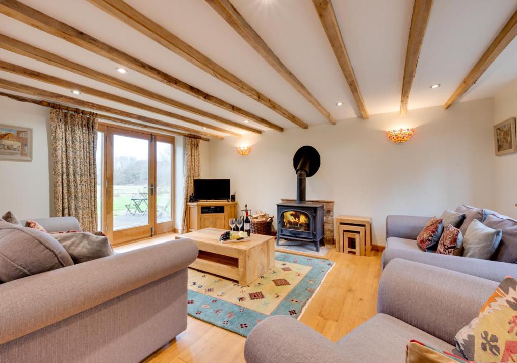 a living room with two couches and a fireplace at Birdsong Barn in Westfield