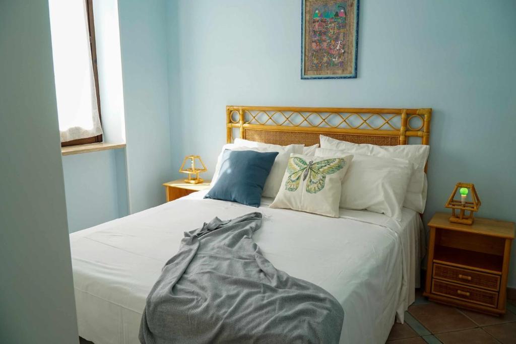 een slaapkamer met een bed met witte lakens en kussens bij Casa Elsa Terrazza con vista by ItalianHost in Maiori