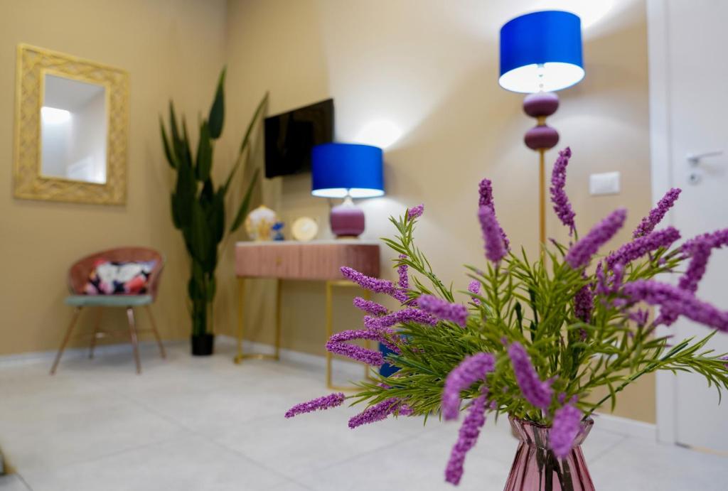 um vaso cheio de flores roxas numa sala em Marchese 124 em Bari