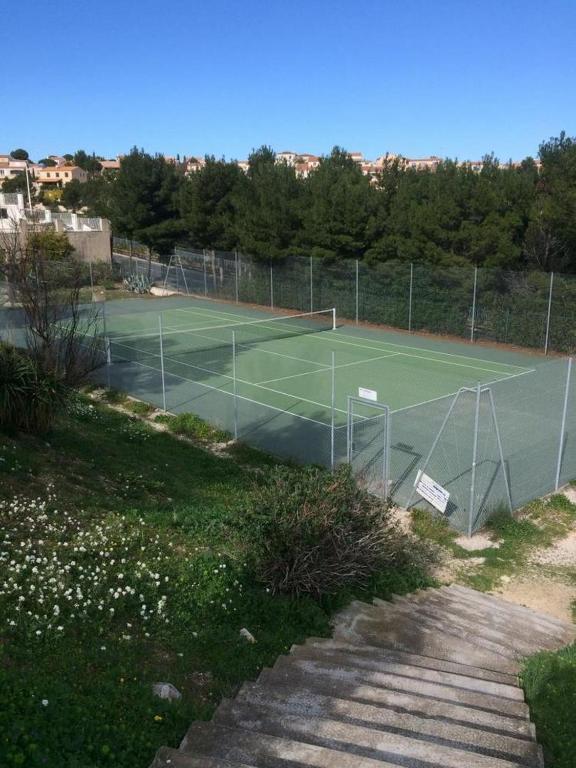 a tennis court with a net on top of it at Le Mooréa 2 est à 5 min de l&#39;hyper centre et plages in Sausset-les-Pins