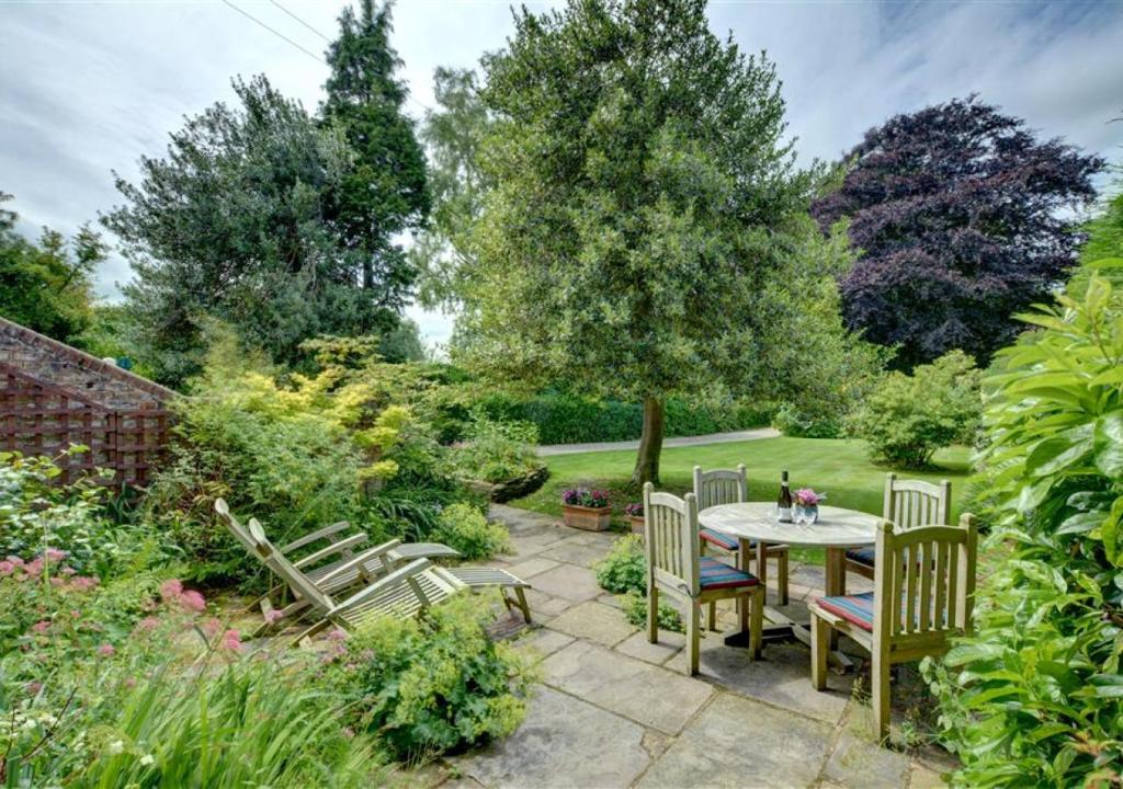 un patio con mesa y sillas en un jardín en Garden Flat, en Sandwich