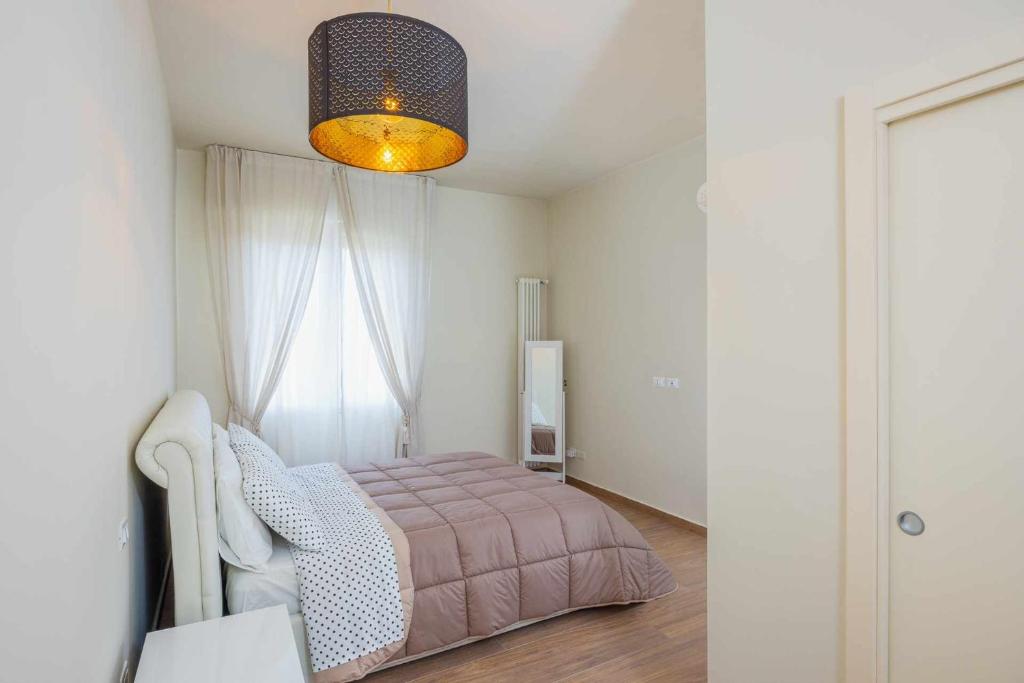 um quarto com uma cama rosa e uma janela em Ci Vuole Leggerezza Apartment Free Parking em Bolonha