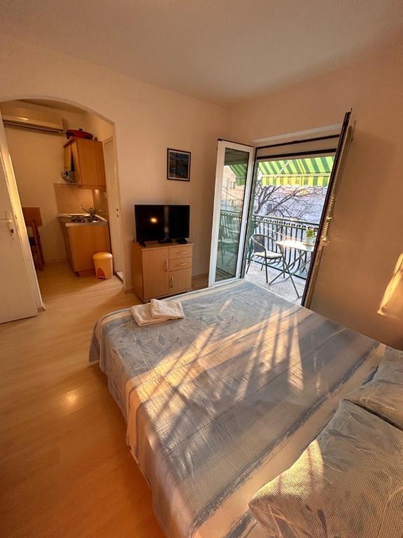 a bedroom with a large bed and a balcony at Apartment Alfirev Vodice in Vodice