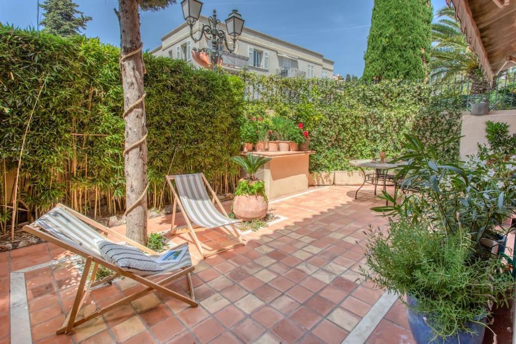 un patio con dos sillas y una mesa en L34 Hermès Suite terrace parking AC 2mins SEA, en Saint-Jean-Cap-Ferrat