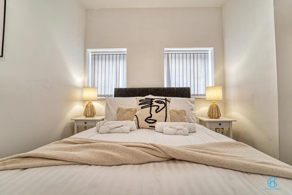 um quarto com uma cama grande e 2 candeeiros em Guest Homes - The Bell Apartment em Stourbridge