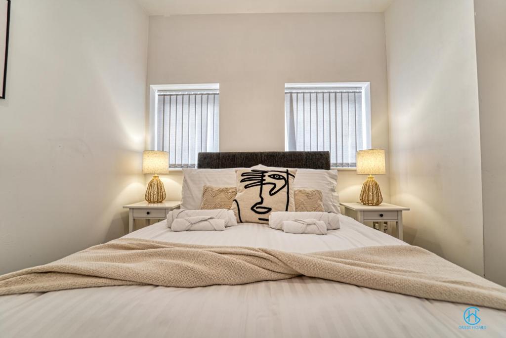 a bedroom with a large bed with two lamps at Guest Homes - The Bell Apartment in Stourbridge
