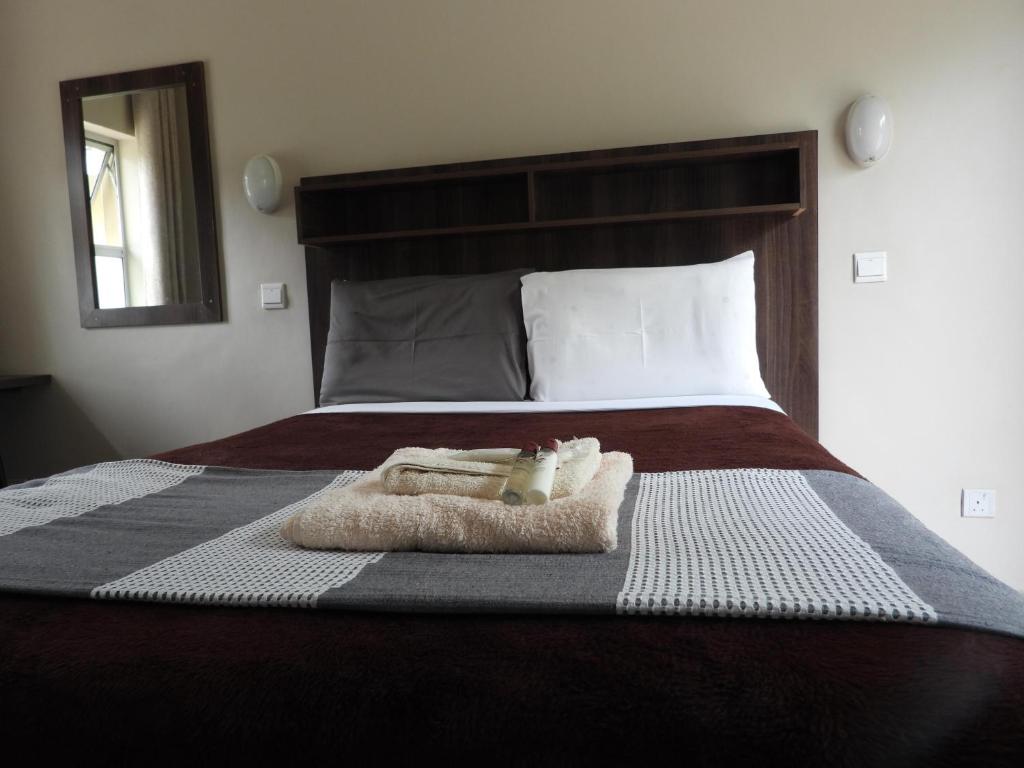 Una cama con una toalla encima. en 2 bedroomed apartment with en-suite and kitchenette - 2070 en Harare