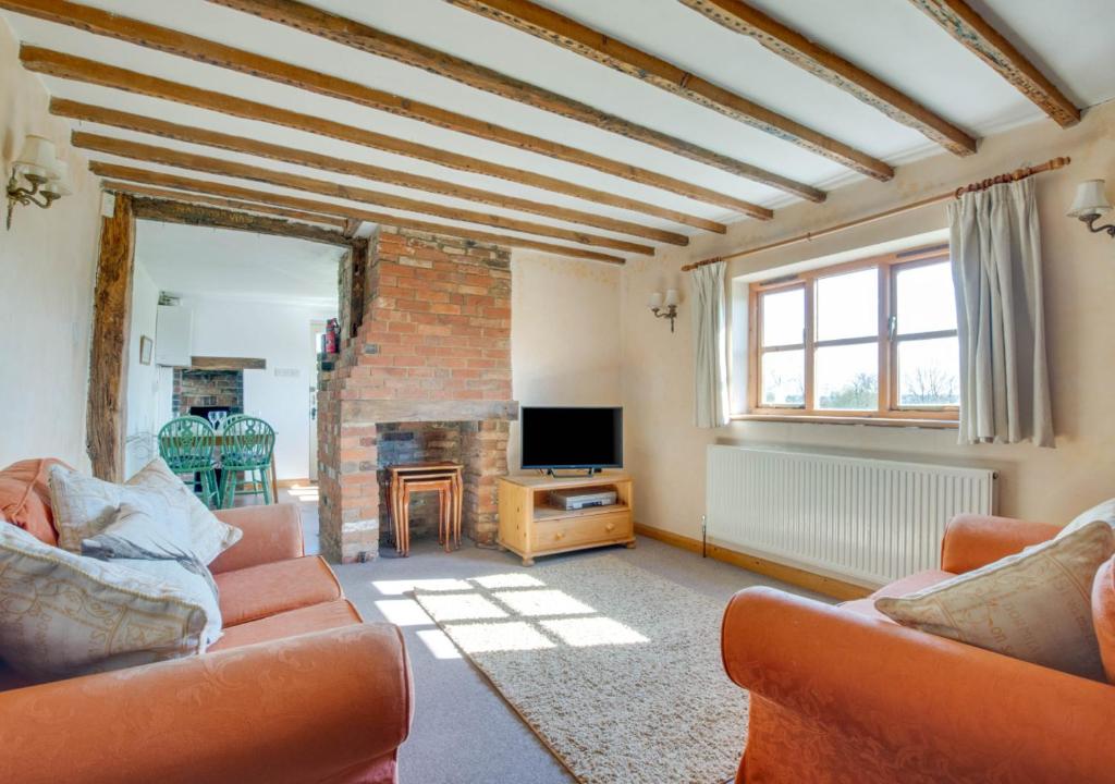 a living room with two couches and a television at Orchard Cottage in Sutton Valence