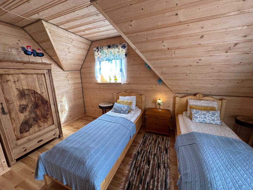 a bedroom with two beds in a log cabin at Domek "Góraleczka " koło Karpacza - z widokiem na góry in Sosnówka