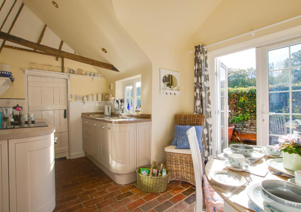 a kitchen with a table and a sink at One The Bungalows in Peasmarsh