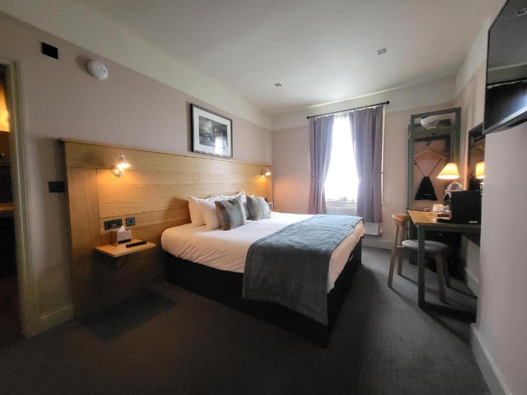 a hotel room with a bed and a desk at The Black Hat in Ilkley