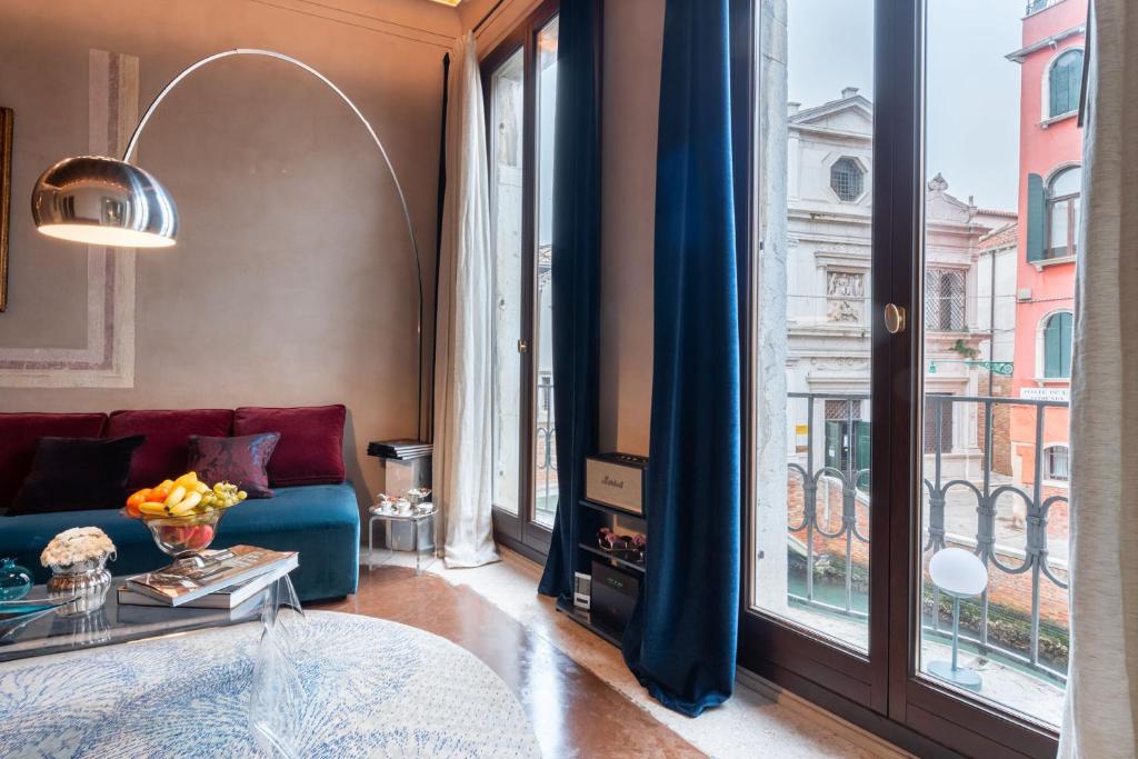 uma sala de estar com um sofá e uma grande janela em Cà dei Dalmati - the Blue Canal View em Veneza