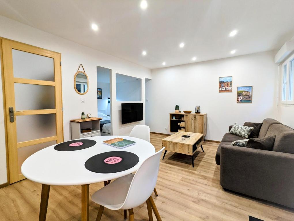ein Wohnzimmer mit einem Tisch und einem Sofa in der Unterkunft A deux pas mer et falaises in Mers-les-Bains