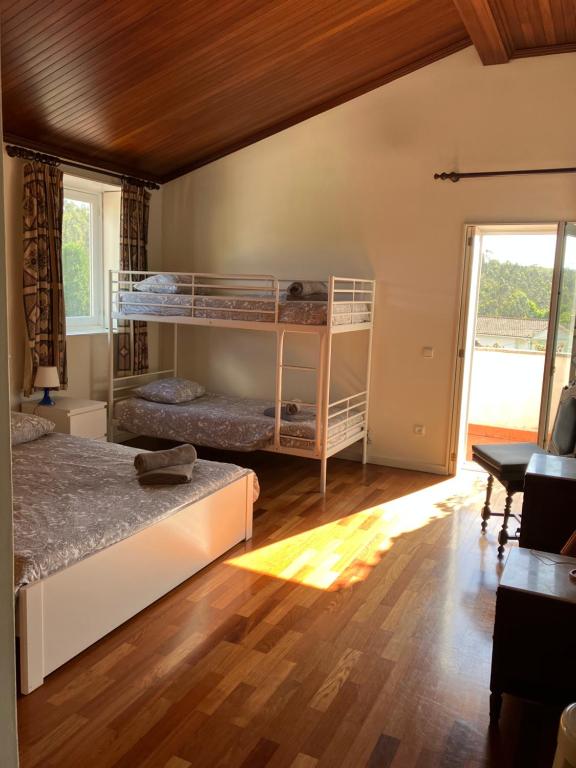a bedroom with two bunk beds and a wooden floor at Citrus Tree House, private pool and garden. in Angeja