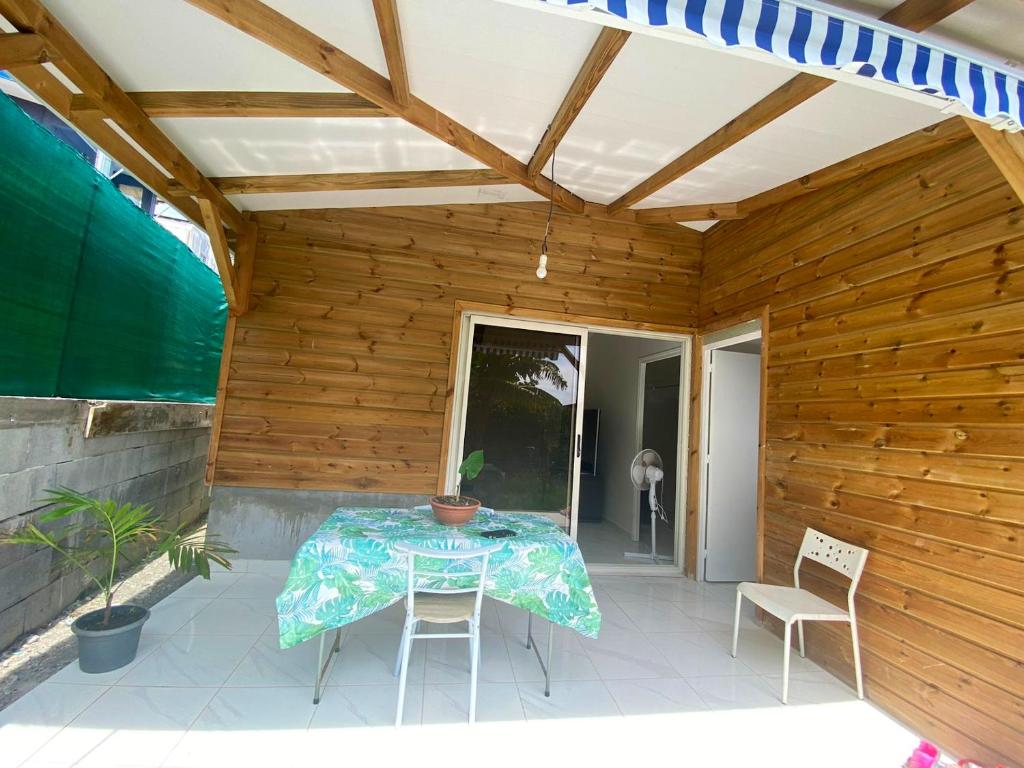 patio ze stołem i krzesłami w obiekcie Bungalow d'une chambre a Schoelcher a 500 m de la plage avec jardin clos w mieście Schœlcher