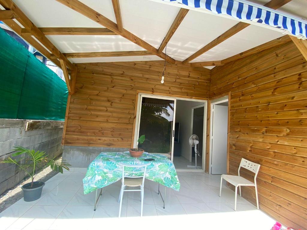 a patio with a table and chairs on it at Bungalow charmant à Schoelcher avec jardin clôturé in Schœlcher