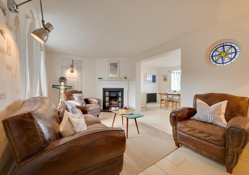 a living room with leather furniture and a fireplace at Napier Cottage in Broadstairs