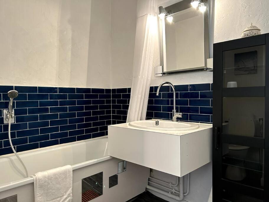 a bathroom with a sink and a tub and a mirror at Appartement vue mer in Soulac-sur-Mer