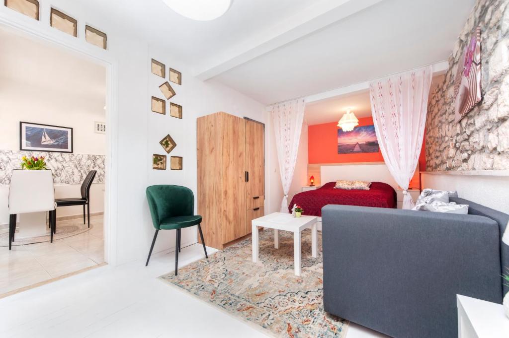 a bedroom with a bed and a living room with a table at Studio Apartment Bisaku in Rovinj