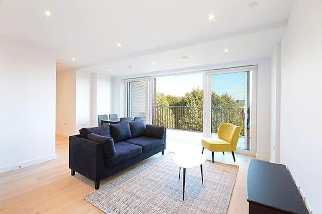 een woonkamer met een blauwe bank en een gele stoel bij Modern & Spacious Luxury Flat-10 min to London Eye in Londen