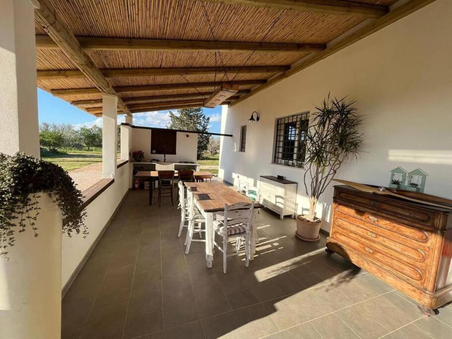 un patio con techo de madera, mesa y sillas en Residenza SA - tra mare e campagna, en Sannicola