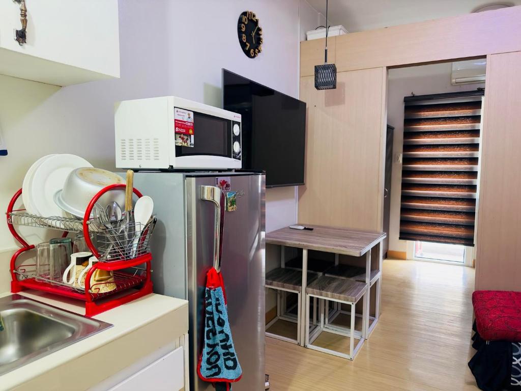 a kitchen with a refrigerator and a microwave at Trees Residences in Manila