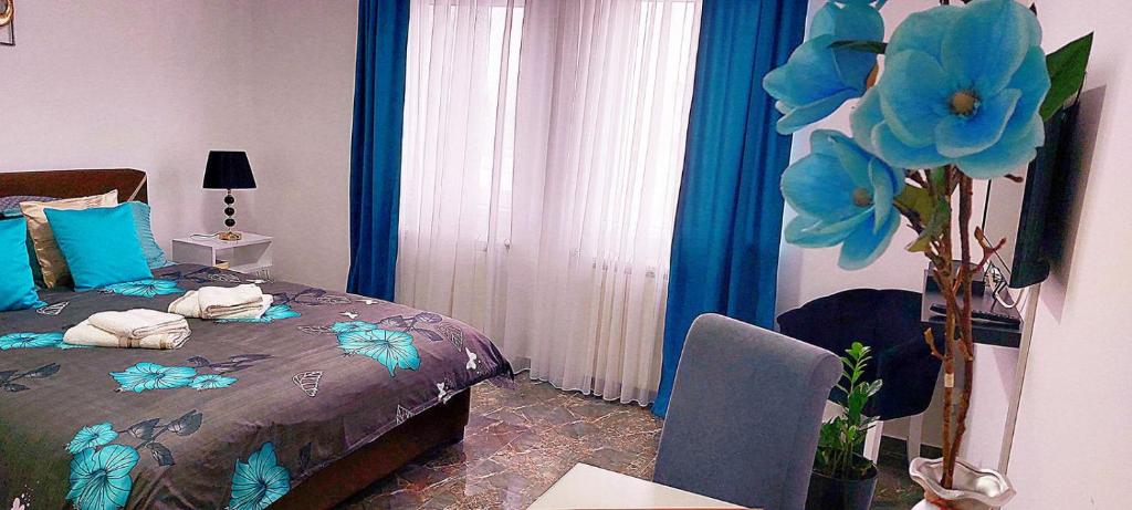 een slaapkamer met een bed met blauwe bloemen erop bij Apartman Milion Banja Koviljača in Banja Koviljača