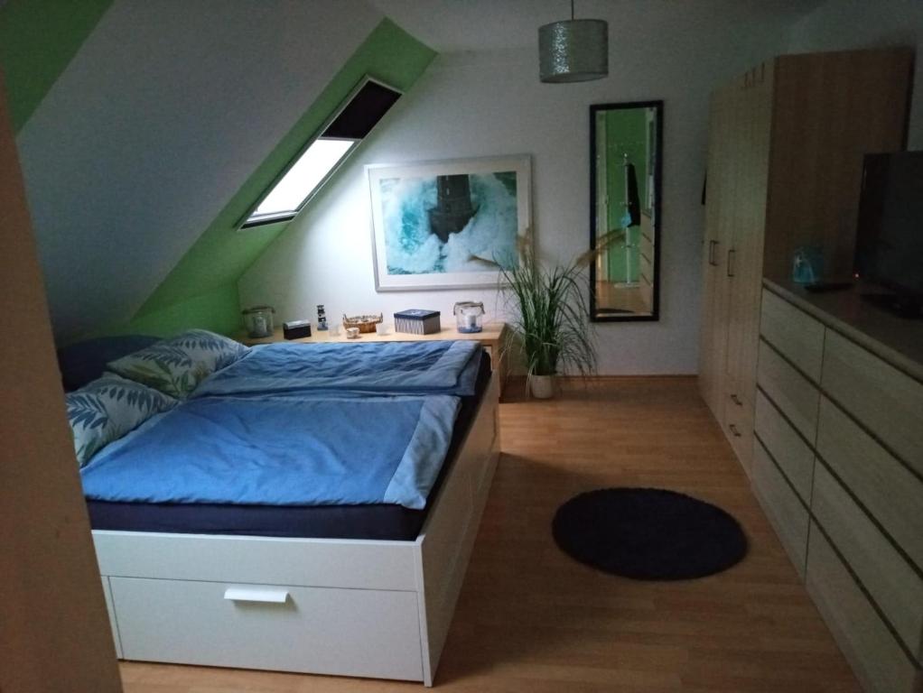 a bedroom with a bed with a blue comforter at Ferienwohnung Hoppe 2 in Pattensen