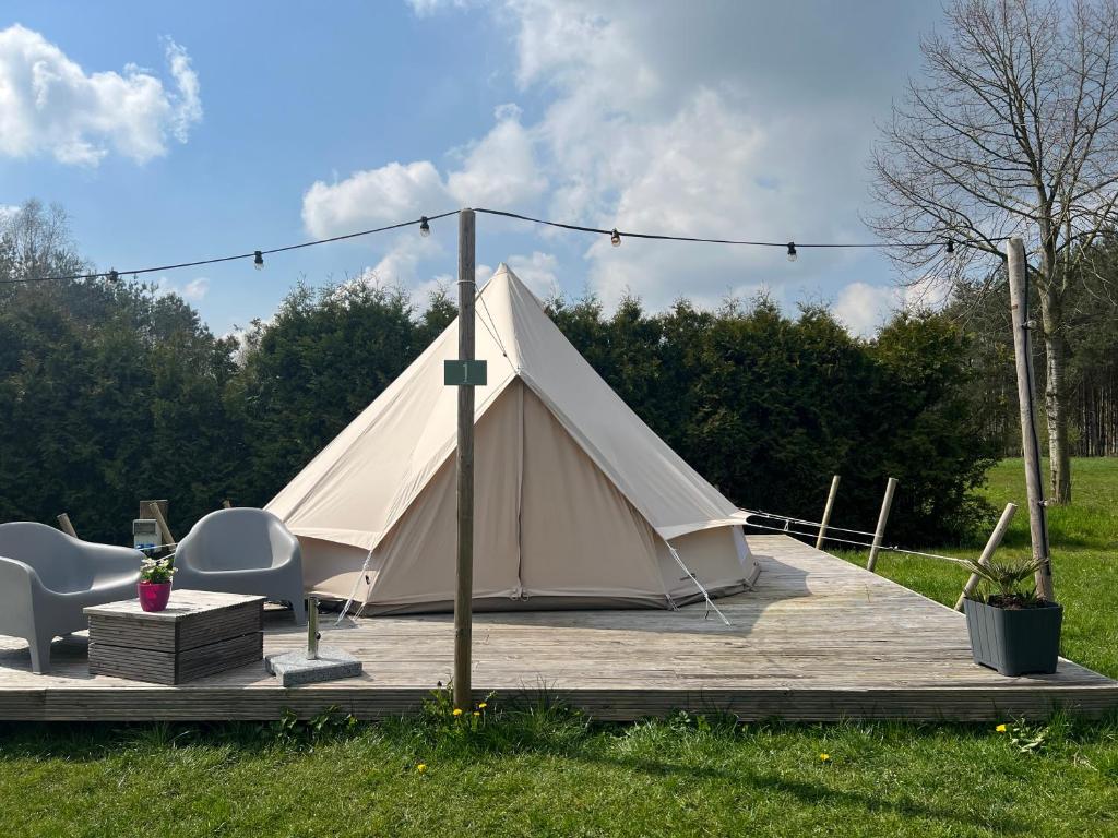 Blesdijke的住宿－Glamplodge met privé sanitair，木制甲板上的白色帐篷