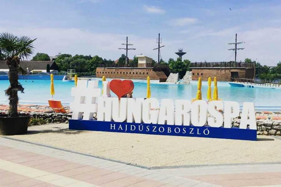 a sign for the entrance to the swimming pool at a resort at Plage Carpe Diem 2 Apartman in Hajdúszoboszló