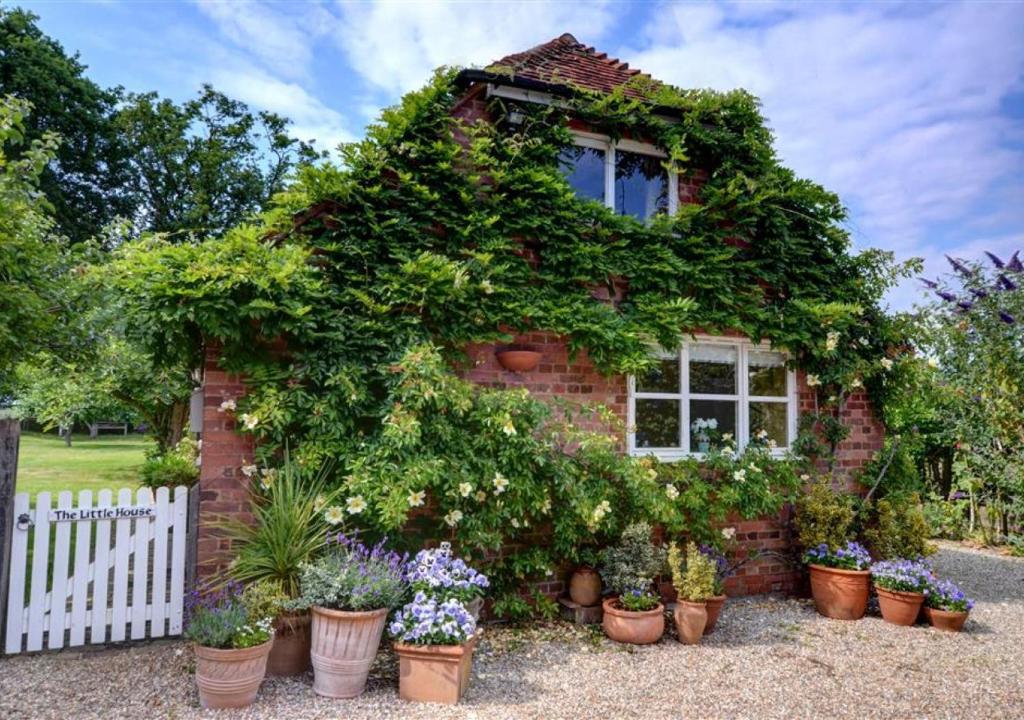 a small brick house with plants in front of it at The Little House in Rolvenden