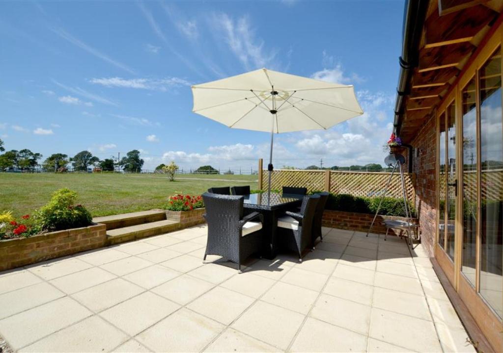 a table and chairs with an umbrella on a patio at The Parlour in Brede