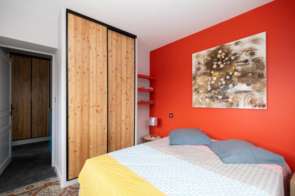 a bedroom with an orange wall and a bed at Propriete spacieuse a Saint Trojan Vue mer in Saint-Trojan-les-Bains