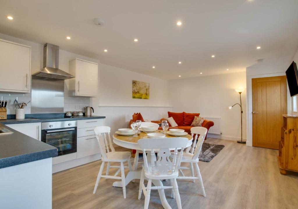 a kitchen and living room with a table and chairs at The Pump House in Hernehill
