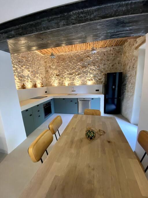 een keuken met een houten tafel en gele stoelen bij Bastide Marseillaise in Aubagne