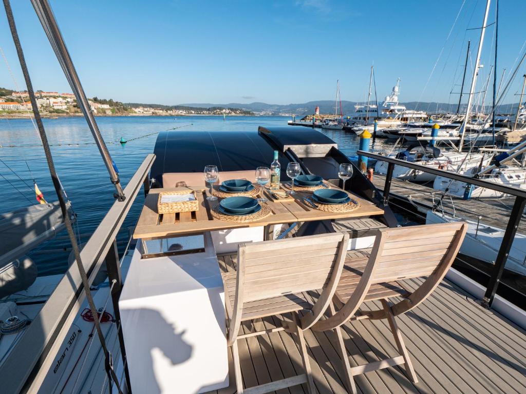 a wooden table and chairs on a boat in the water at Casa Flotante Sanxenxo in Sanxenxo