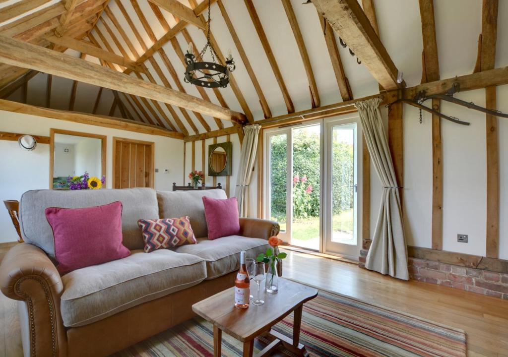 a living room with a couch and a table at Wagon Lodge at Forstal Farm in Tenterden
