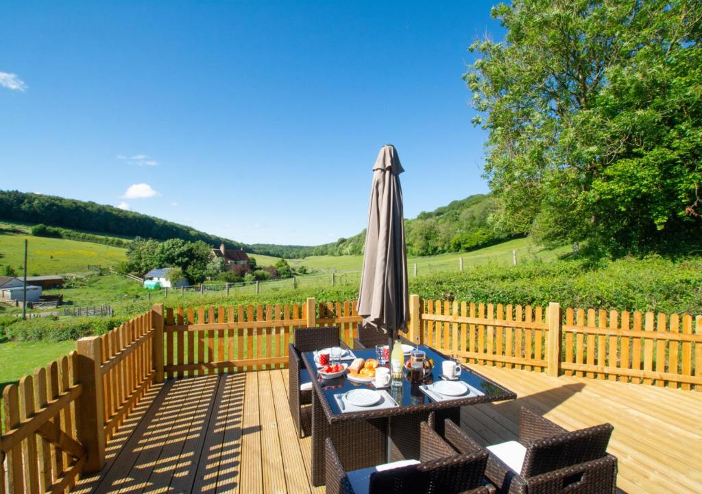 a patio with an umbrella and a table and chairs at Valley View in Upper Hardres