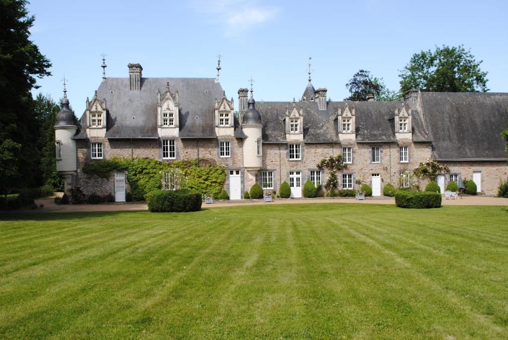 ein altes Schloss mit großem Rasen davor in der Unterkunft Suite dans un château dans le Haut Anjou in Pouancé